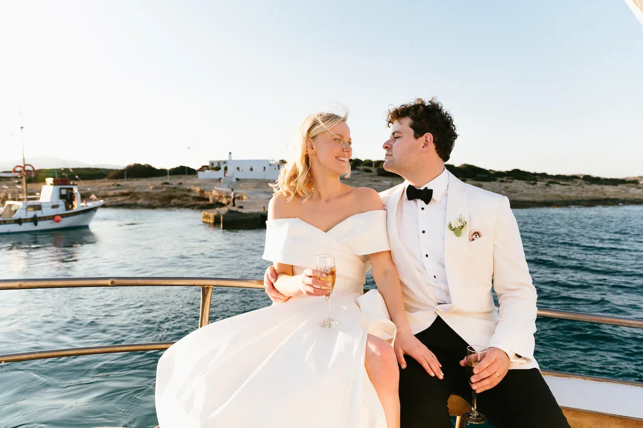 Kayla Cross and her husband, Grayson, sitting together on a boat on their wedding day in Koufonisia, Greece.